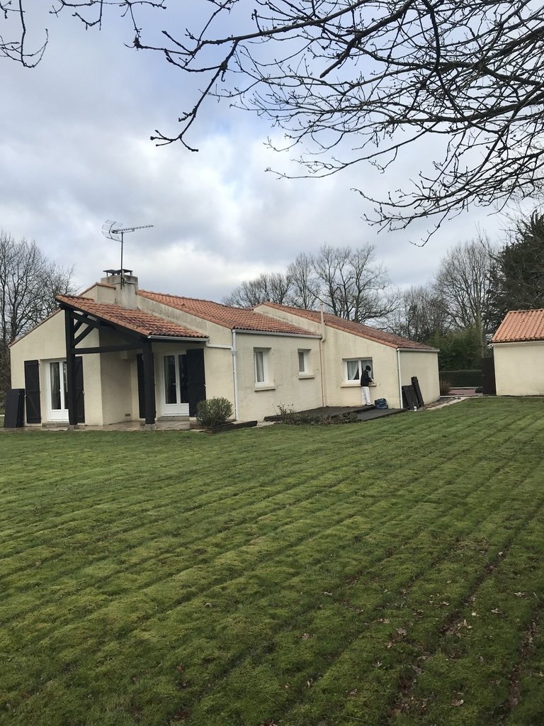 Façade des Sorinières envahie par mousses et pollutions, murs ternis par les intempéries.