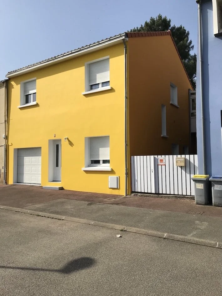 Ravalement de façade à Bouguenais aux couleurs chaudes jaune et orange, pour une maison rayonnante près de Nantes.