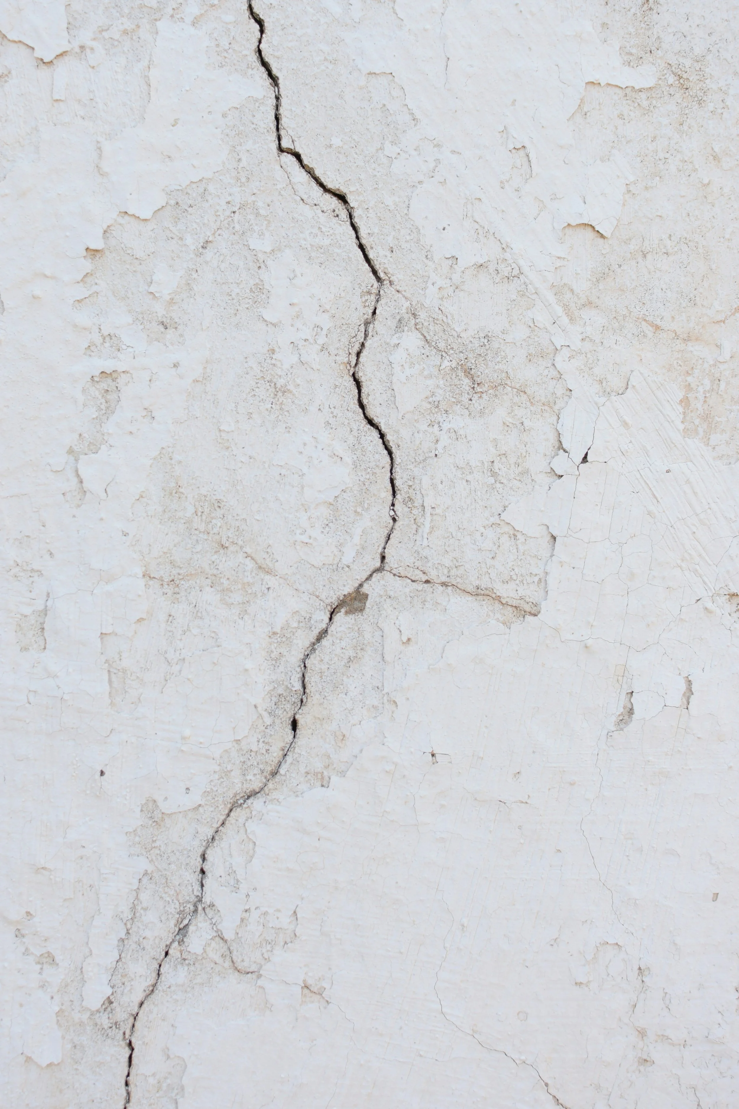Mur blanc avec une fissure centrale.