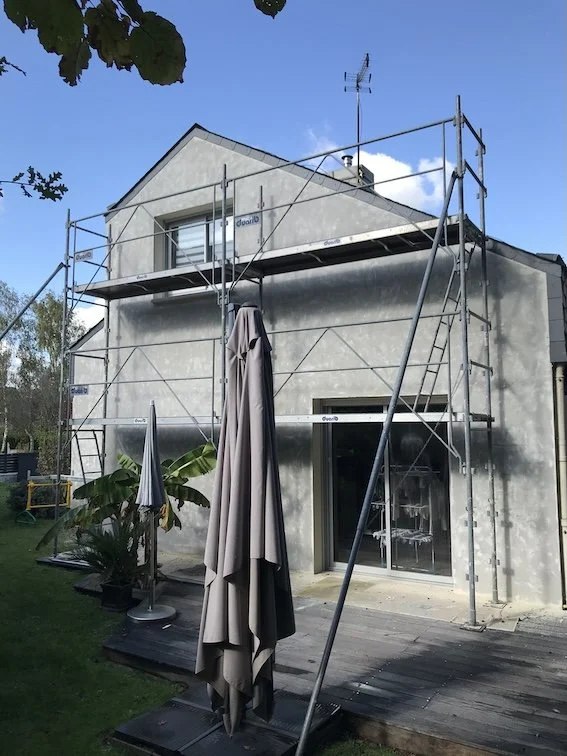 Nettoyage haute pression des façades suivi du traitement des fissures par entaillage et pose de bandes souples anti-mouvement.