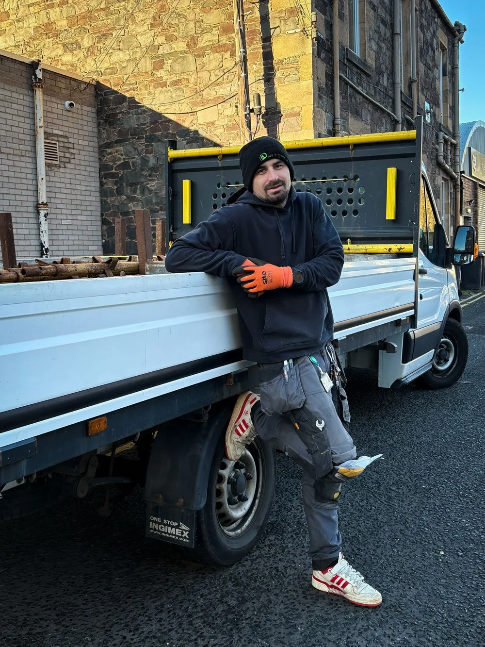 TEO,  head installer at S&P Renewables, Galashiels. Standing against a white wall with the S&P logo in the background