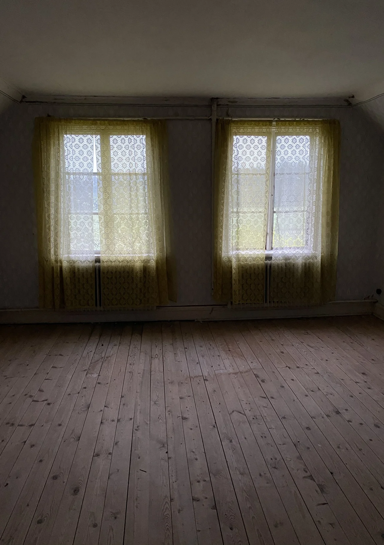 Film location in Gotland - Empty abandoned room. Two windows with curtains