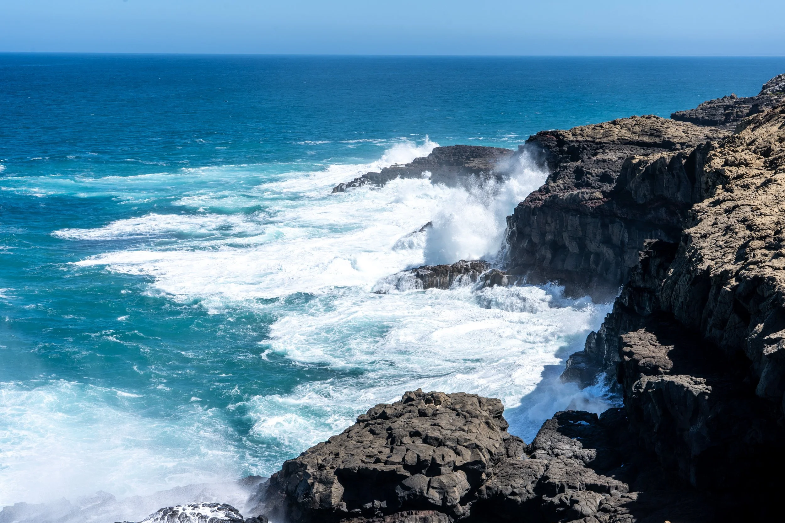 Ocean waves crashing against rocky cliffs.