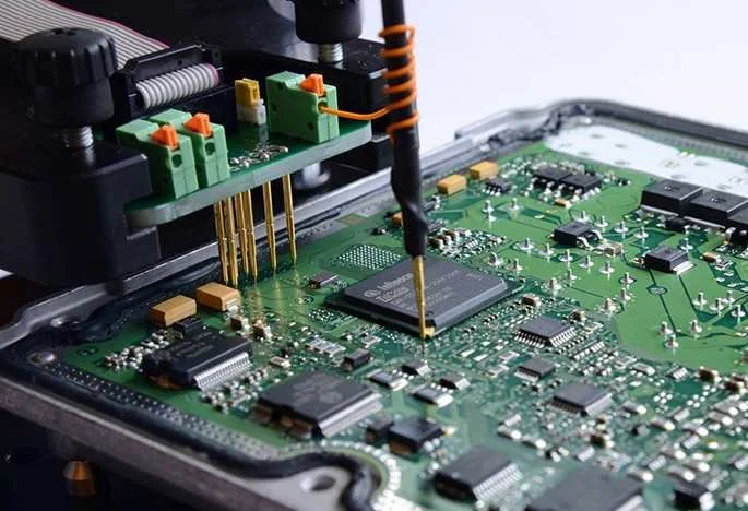Close-up of a printed circuit board (PCB) with a robotic soldering or testing tool working on an integrated circuit.