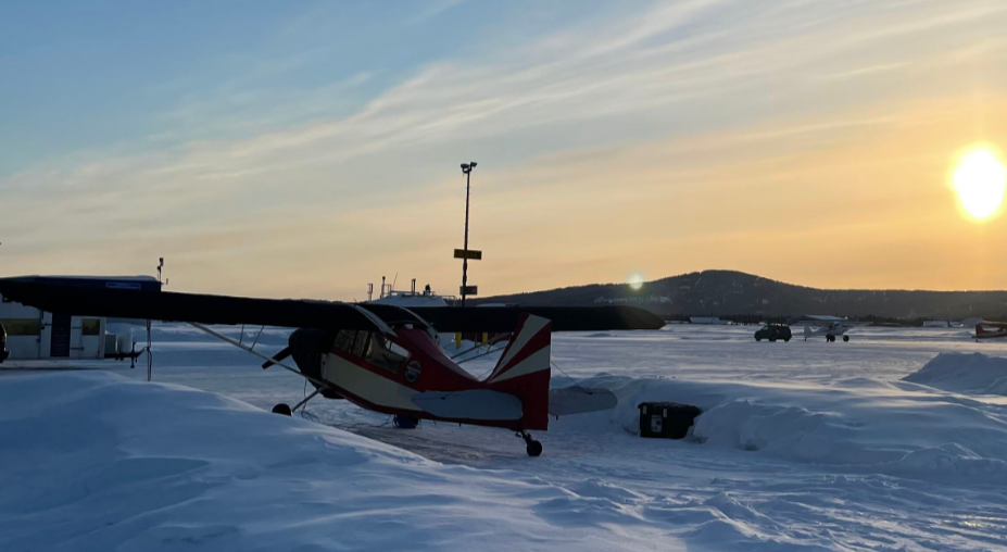Snowy Alaskan landscape with a small aircraft and distant hills; links to the ‘About Us’ page outlining collaboratory groups, researchers, and goals, with Portland State University noted as a collaborator.