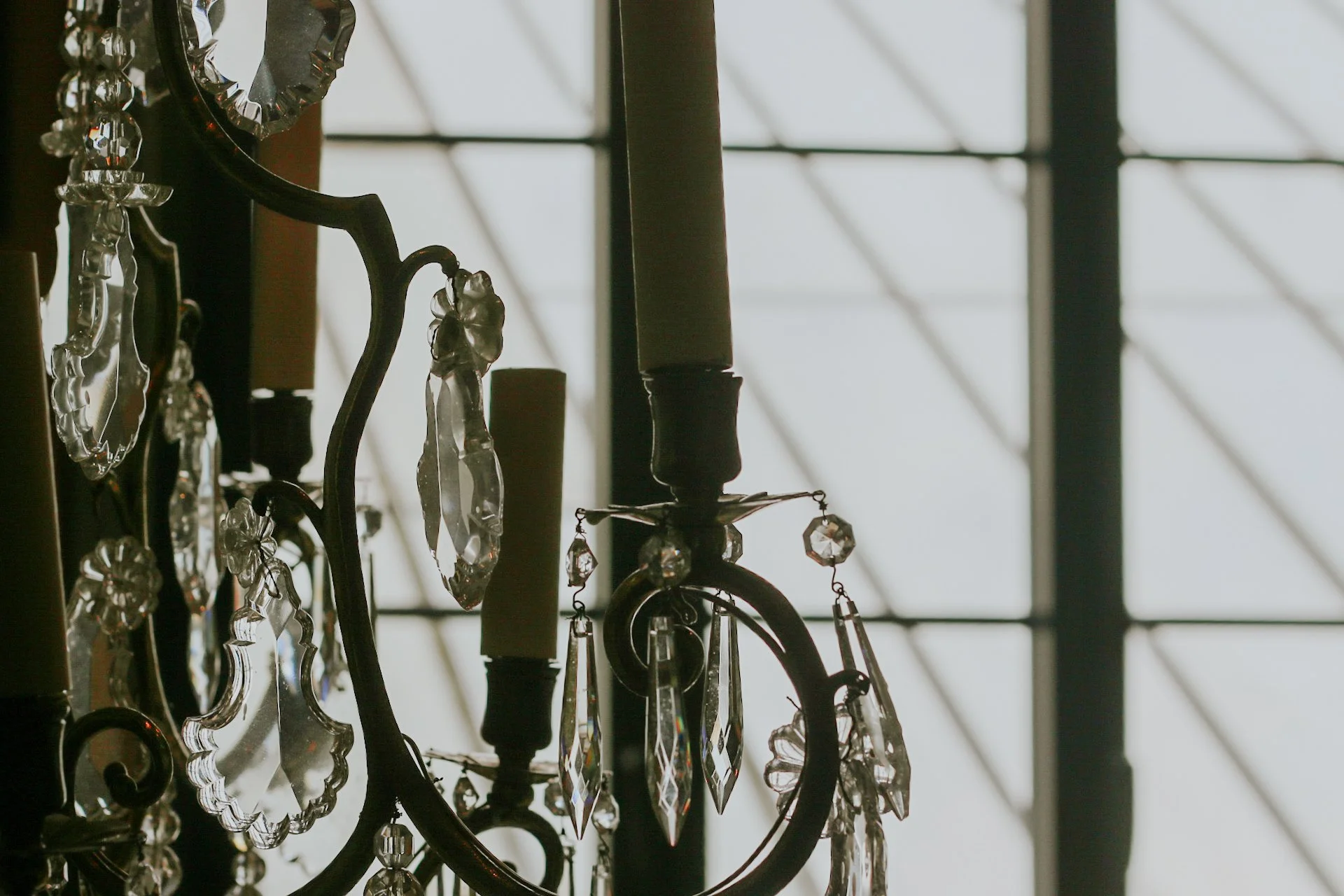 Décoration en cristal d'un chandelier avec une grille géométrique en arrière-plan.