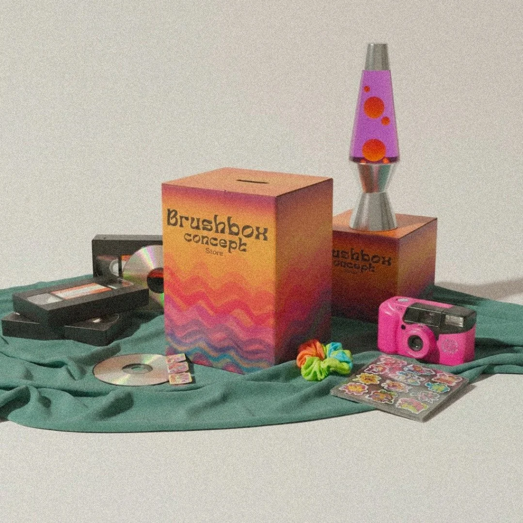 Colorful toy box and lava lamp on green fabric with stickers, camera, VHS tapes, and CDs scattered around.