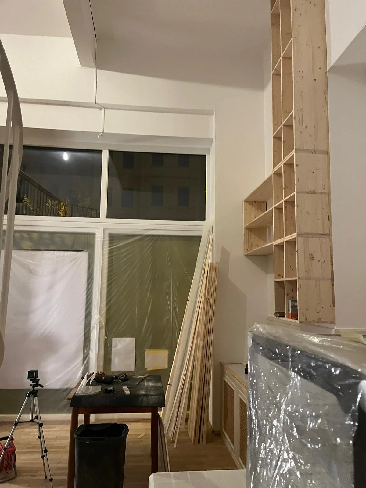 Innenraum einer Wohnung oder eines Hauses, im Umbau, mit Bauholz, Werkzeugen und einem Stativ.