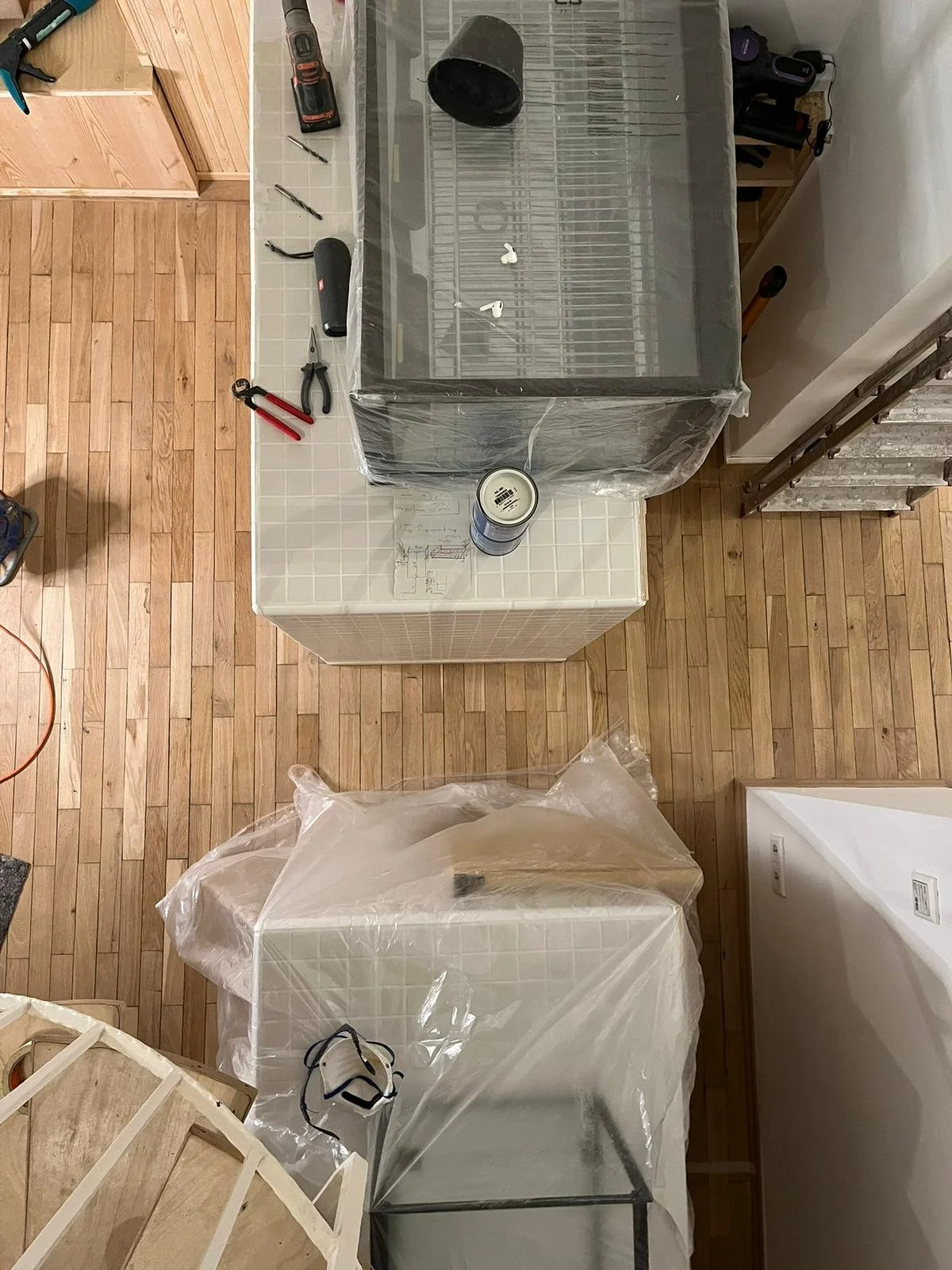 Arbeitsseite mit Werkzeugen, eine große Schneidmaschine, eine kleine Glasvitrine, Werkzeugkasten und Schrauben