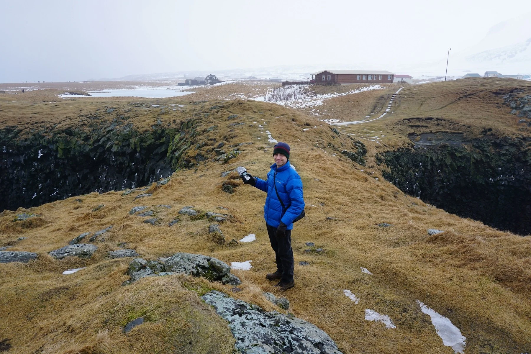 Travis Vengroff records sound effects in Iceland with a microphone for a horror podcast.
