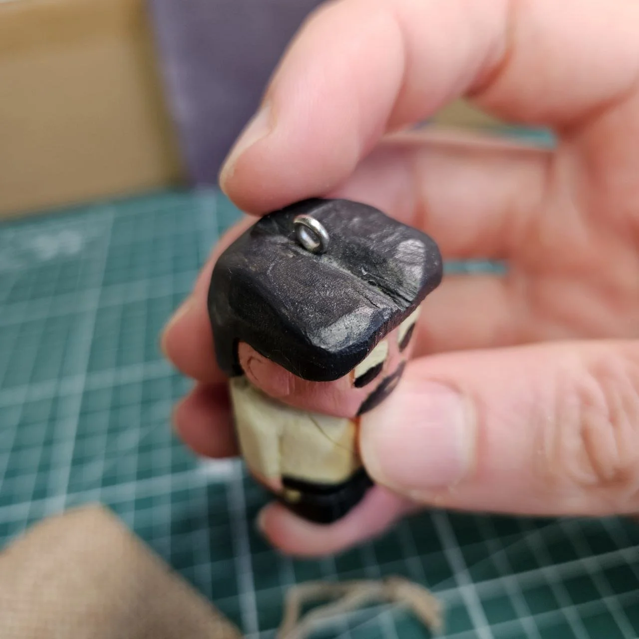 Miniatura di un fiore in legno decorato con colori e dettagli realistici.