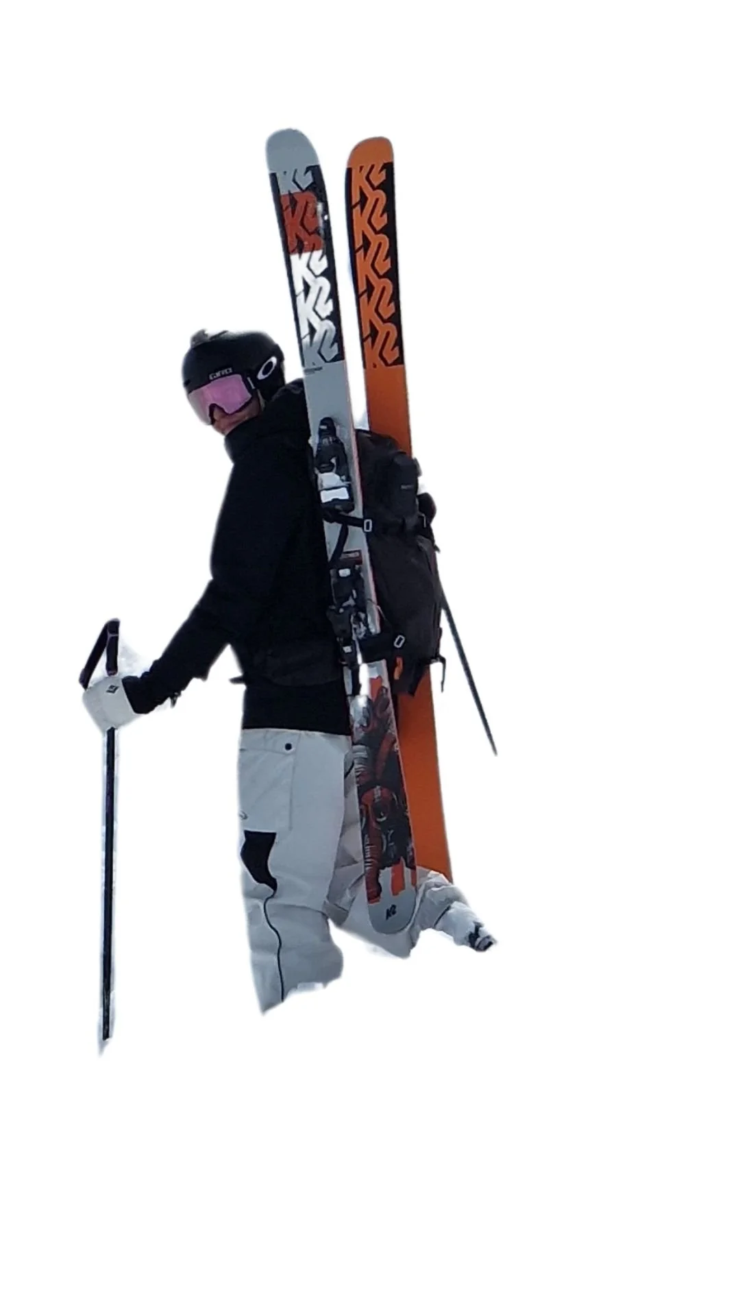 Skieur de snowboard avec une casquette, portant des skis et une veste noire, dans la neige.