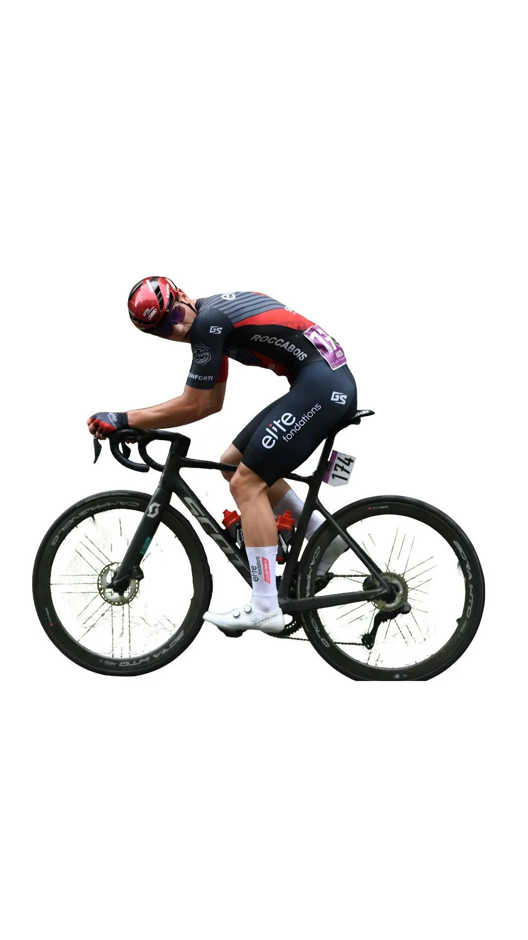 Un cycliste en pleine course, portant un casque rouge, un maillot noir avec des logos, et pédalant sur un vélo de course.