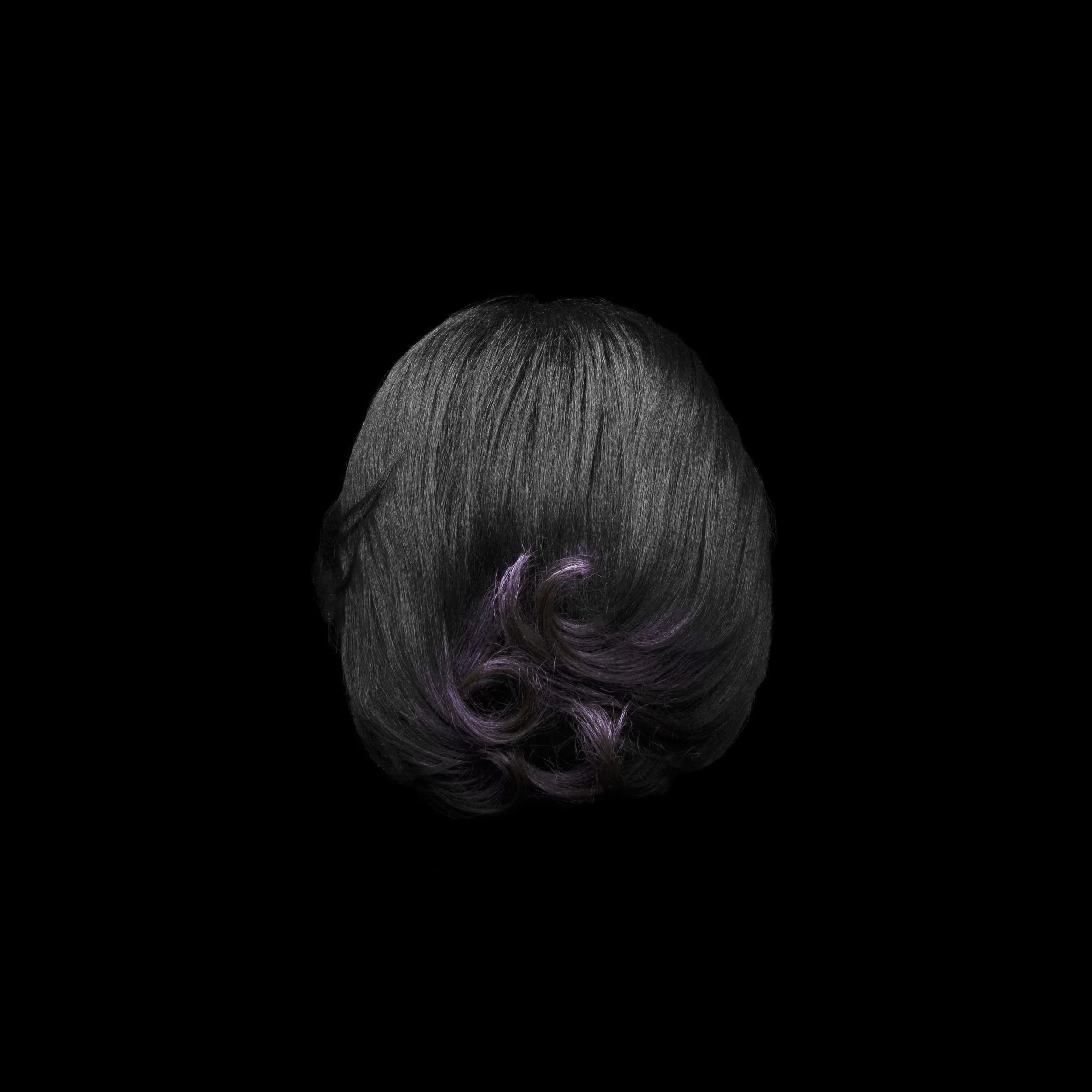 Back of a person's head with dark hair and purple curled tips, against a black background.
