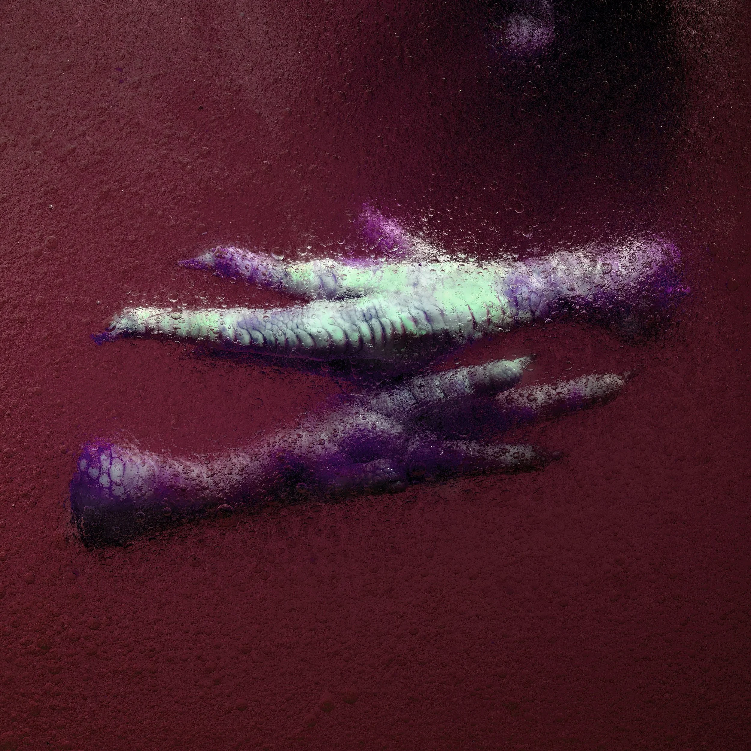 Close-up of a person's lips and fingers pressed against a textured, pinkish-red surface with bubbles and iridescent colors.