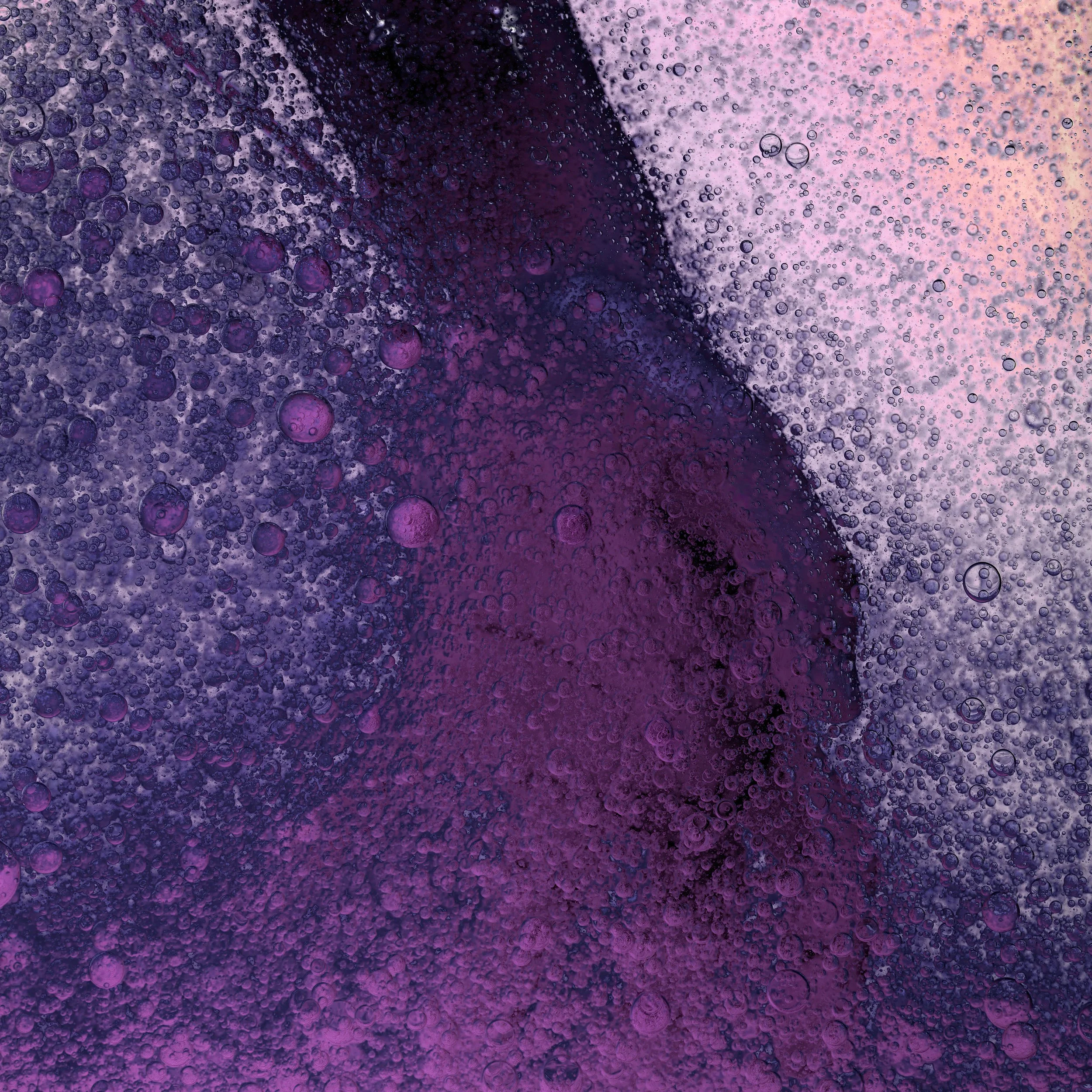 Close-up of a purple and pink abstract surface with numerous bubbles.