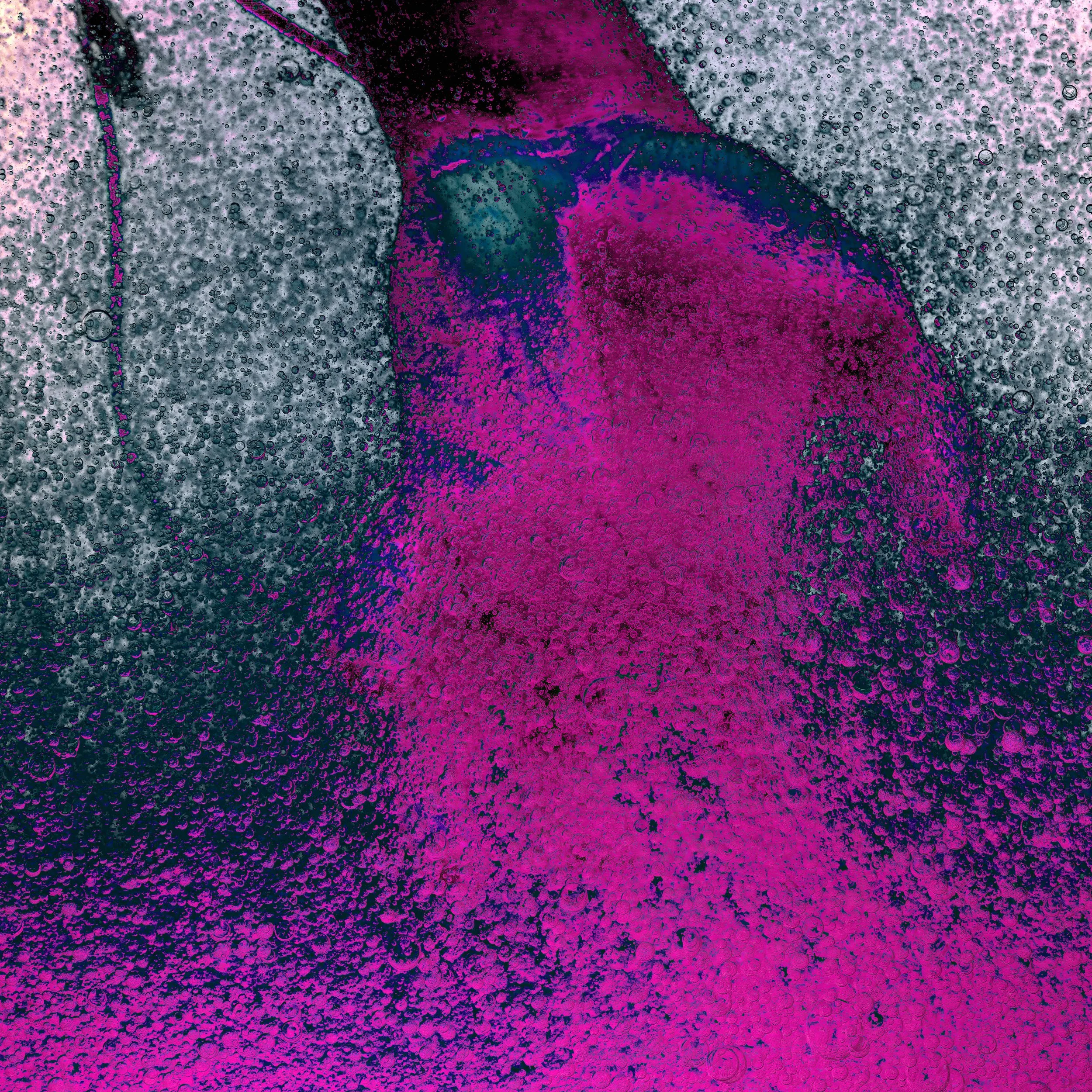 Close-up of a colorful explosion of bubbles and foam with pink, purple, and gray colors.