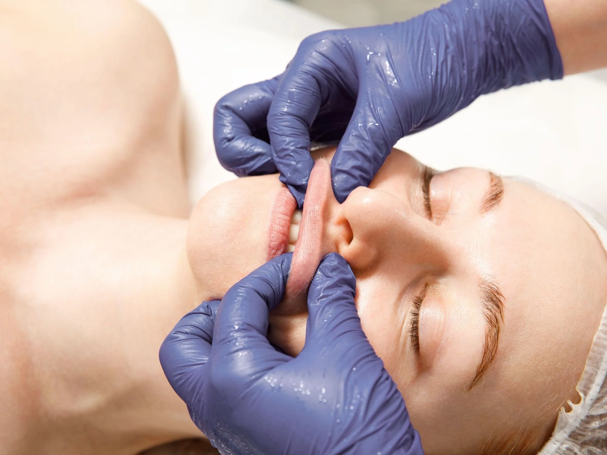 Massage therapist applying intra-oral and external massage for TMJ treatment
