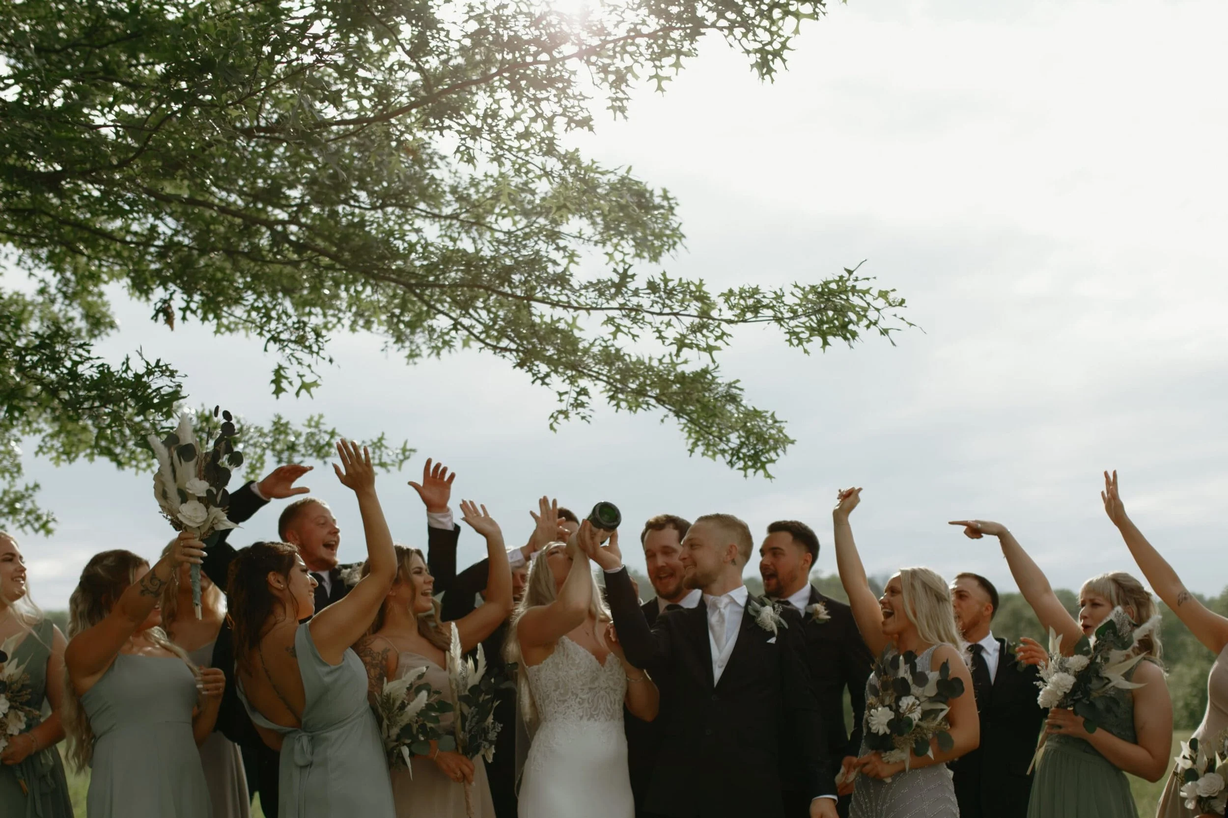 Wedding party celebrating together outdoors at a Galena Illinois wedding, documentary wedding photography by Nicole Kilday