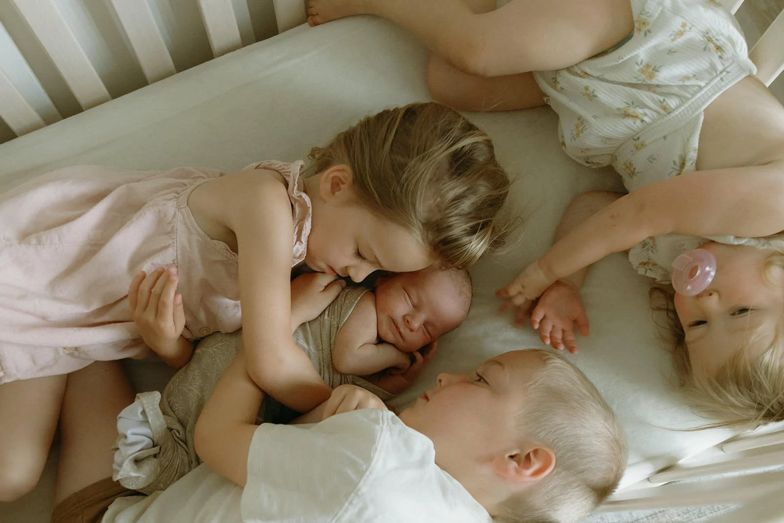 Candid overhead newborn session with sibling meeting baby for the first time in McHenry County Illinois, Nicole Kilday Photography