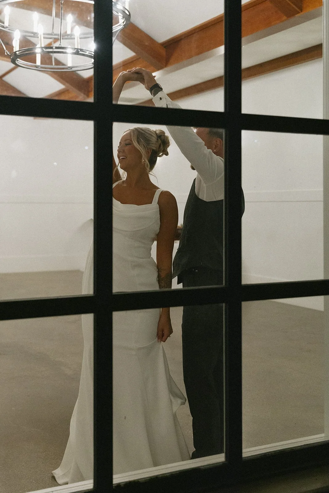 Groom spinning his bride during a private dance being captured through an outdoor window at the Crawford in Naperville IL