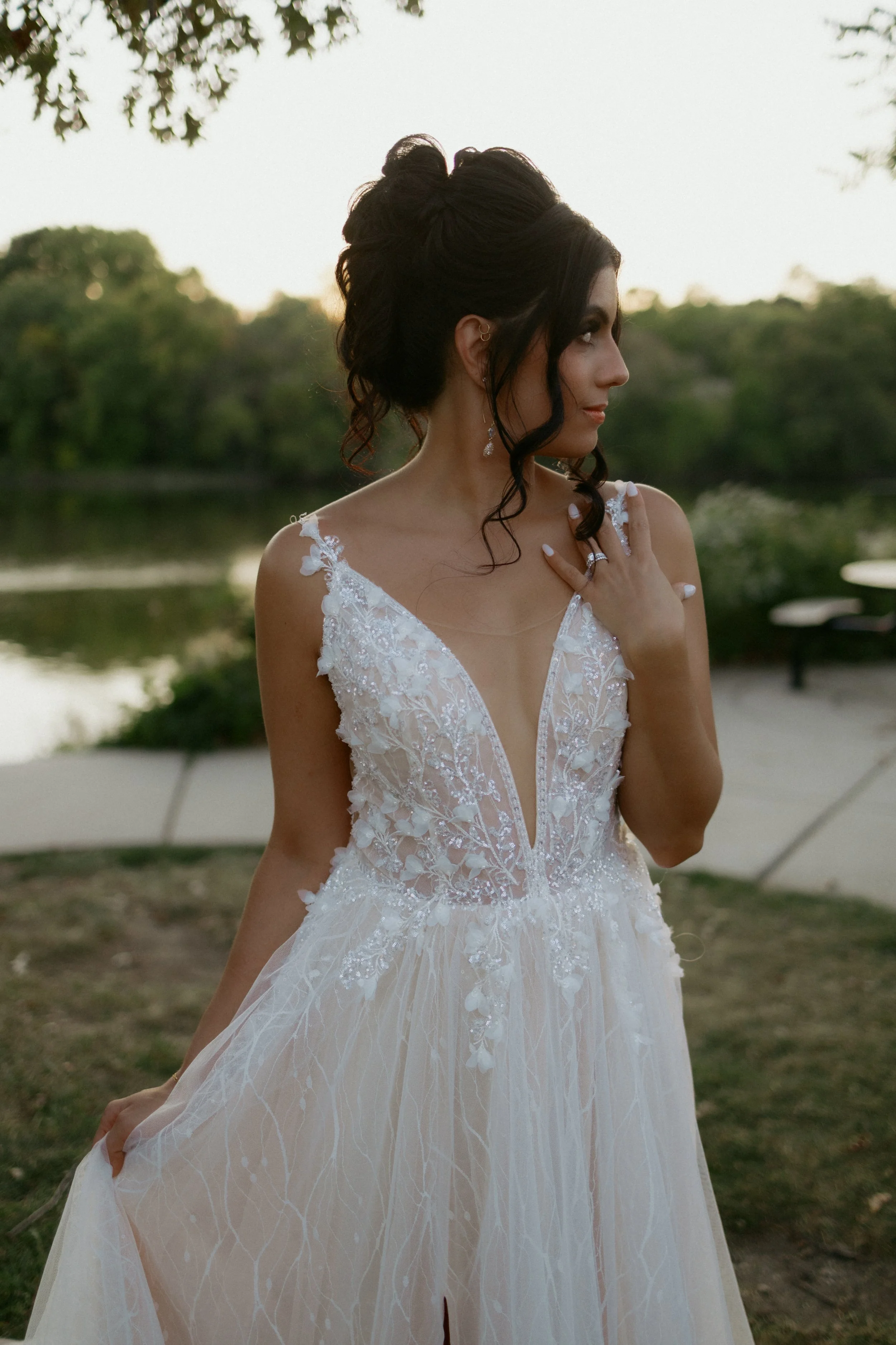 Bride in a deep-v lace gown during sunset portraits near a waterfront, McHenry County Illinois wedding photography by Nicole Kilday