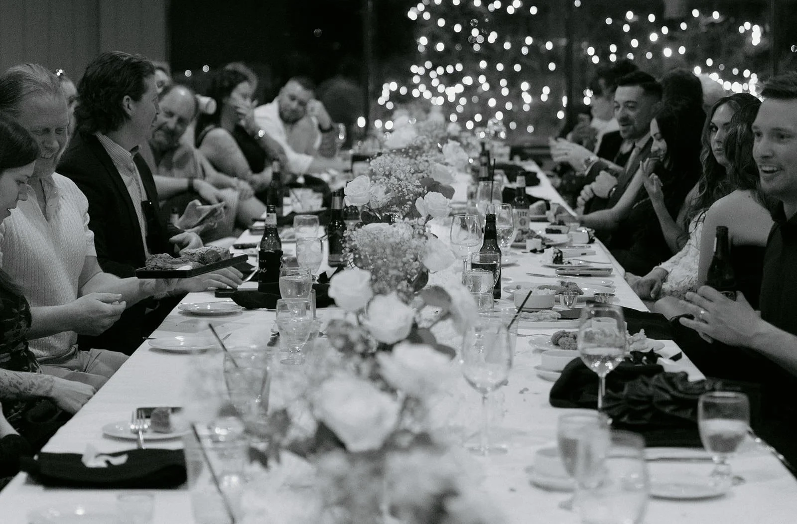 Guests gathered around a long dinner table during an intimate wedding reception in Lake Geneva Wisconsin, photographed by Nicole Kilday