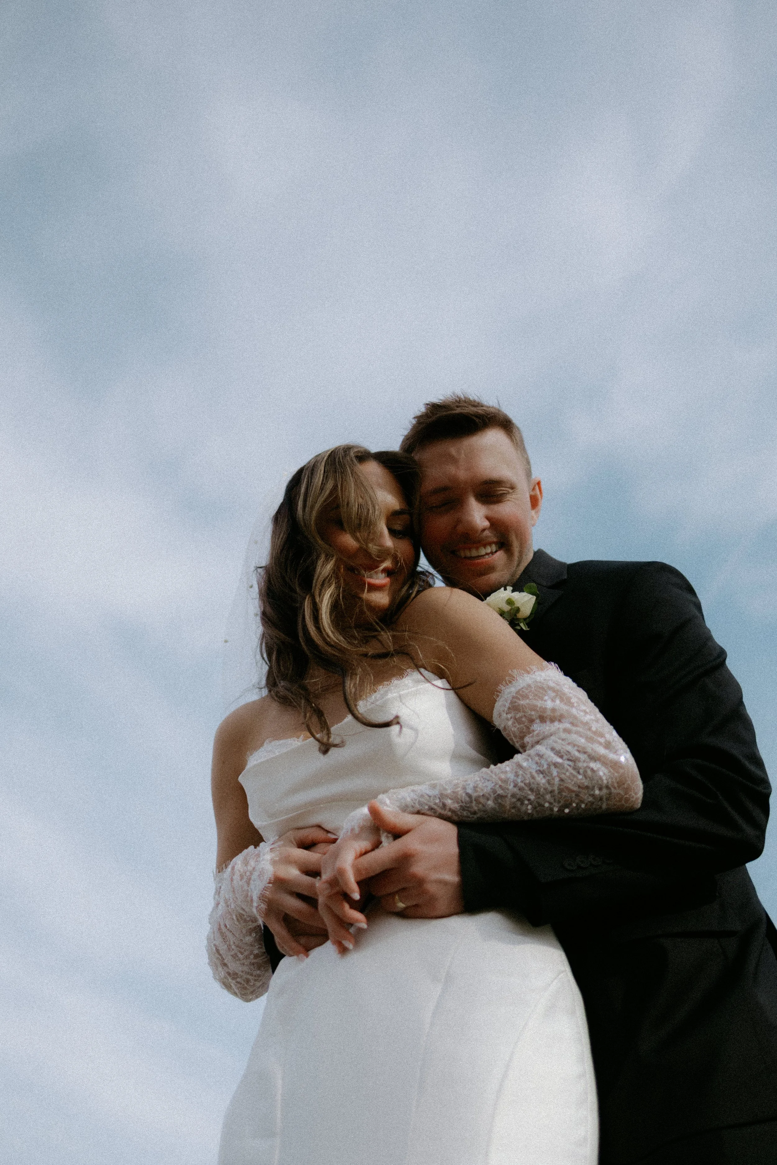 Couple laughing during their wedding day from a below point of view by Nicole Kilday