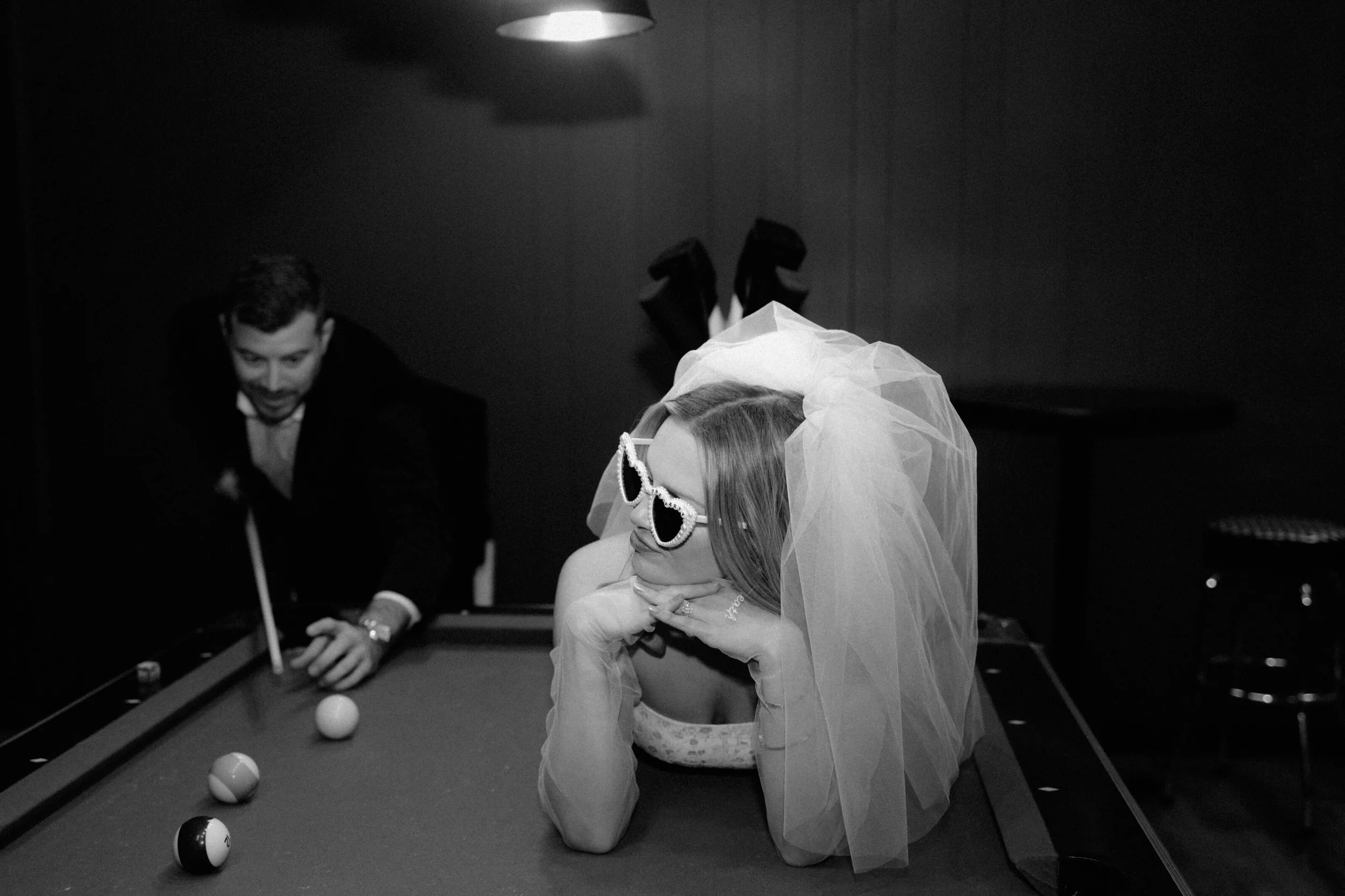 Couple playing pool and being themselves during their bowling alley engagement session by Nicole Kilday.