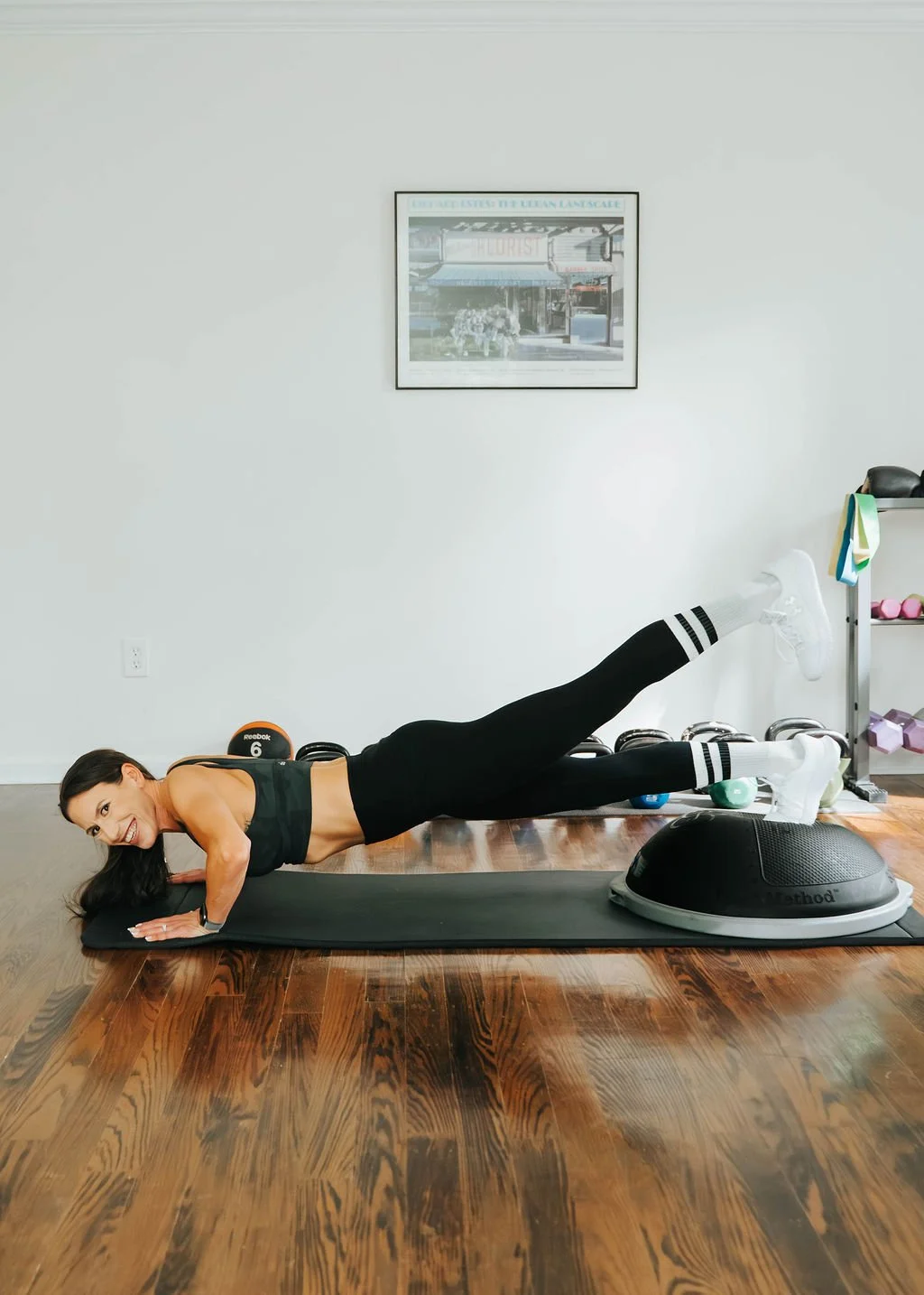 Woman doing a plank exercise on a yoga mat in a gym or fitness studio.