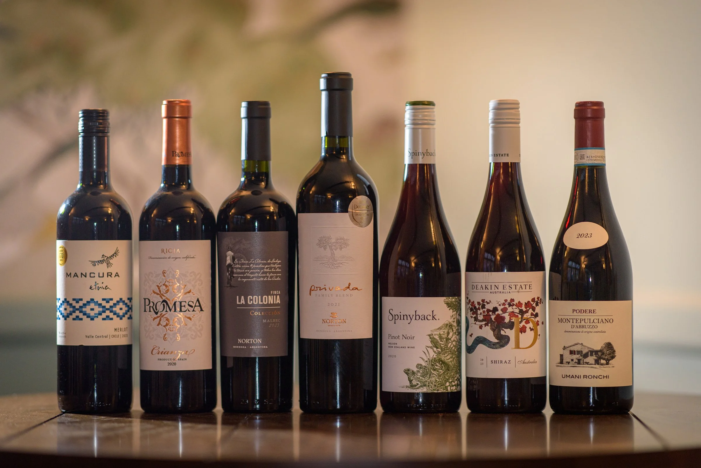 A selection of red wine bottles displayed together, perfect for pairing with seasonal dishes at the pub