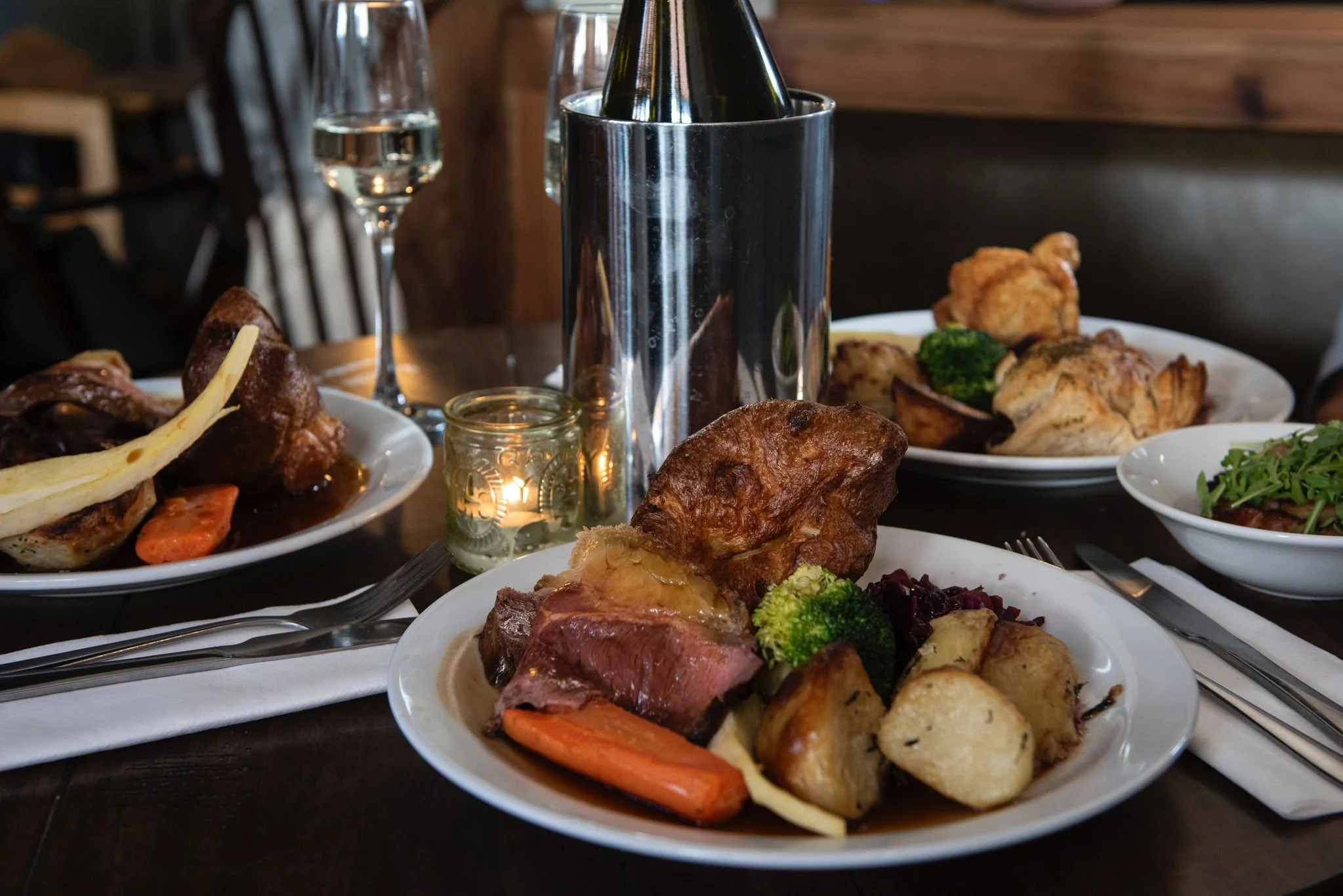 Seasonal dishes served at the pub featuring a classic Sunday roast with Yorkshire pudding, roast potatoes, broccoli, and carrots