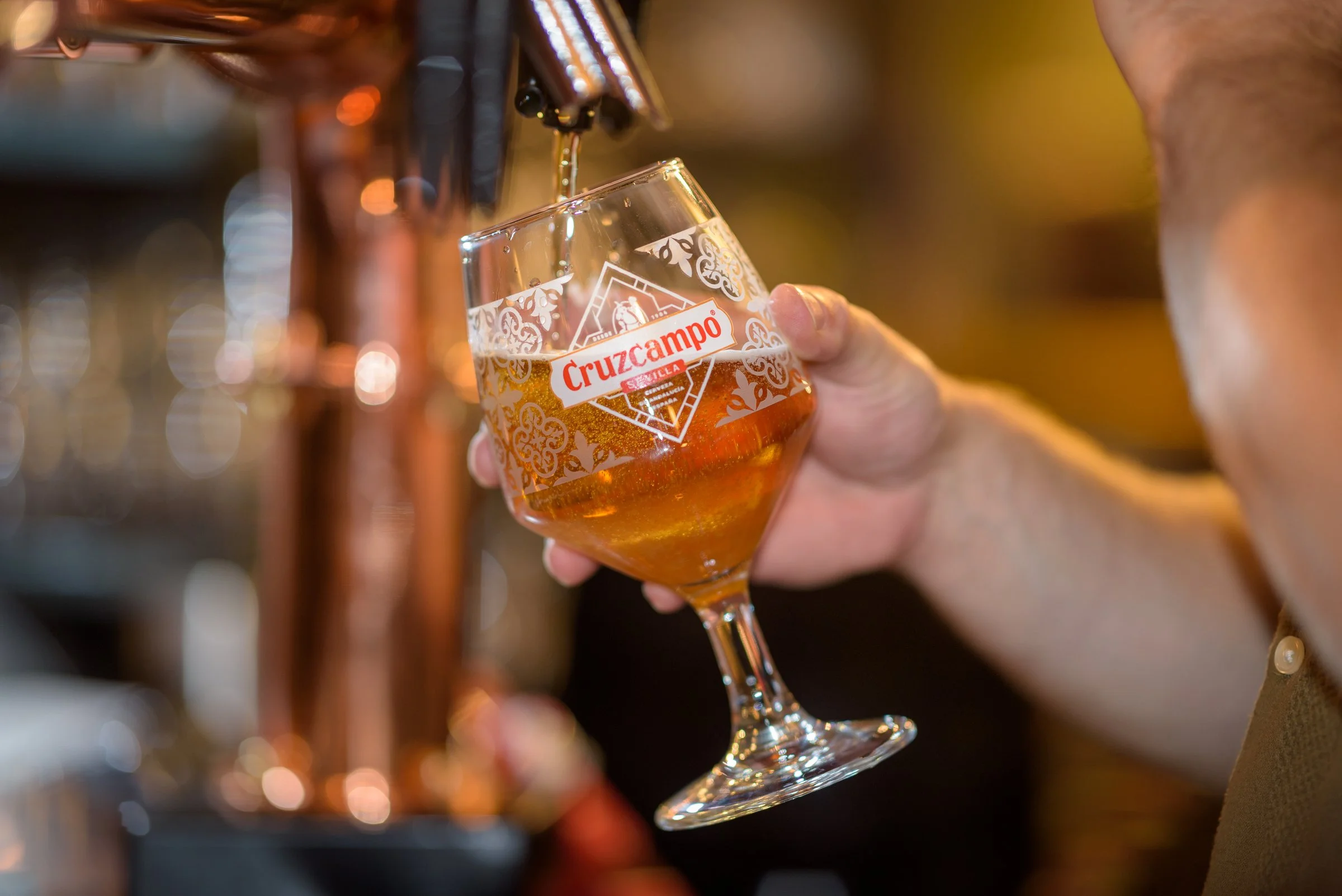 A chilled glass of Cruzcampo beer being served, the perfect partner for seasonal dishes