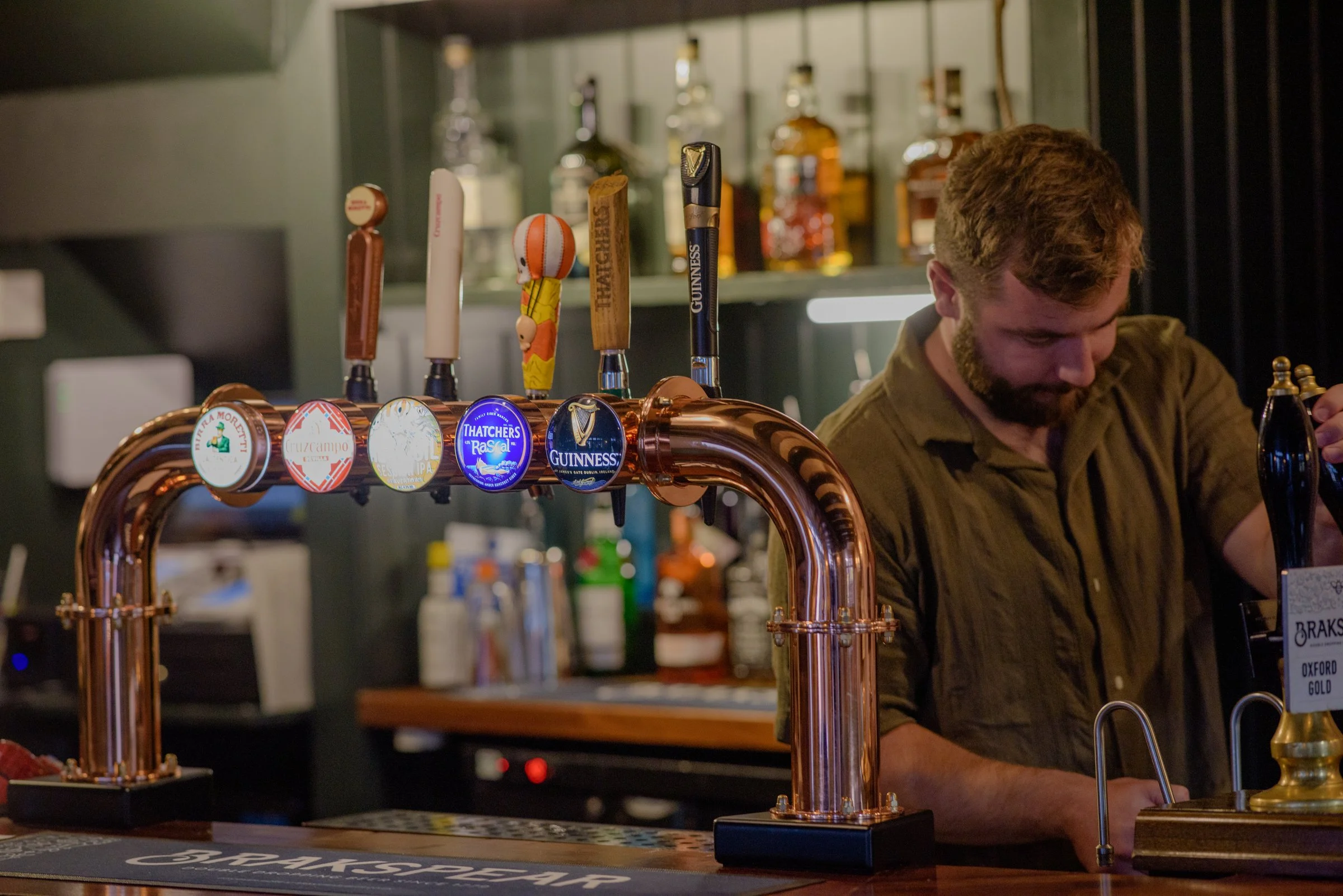 Bartender serving drinks at the bar, complementing seasonal dishes available