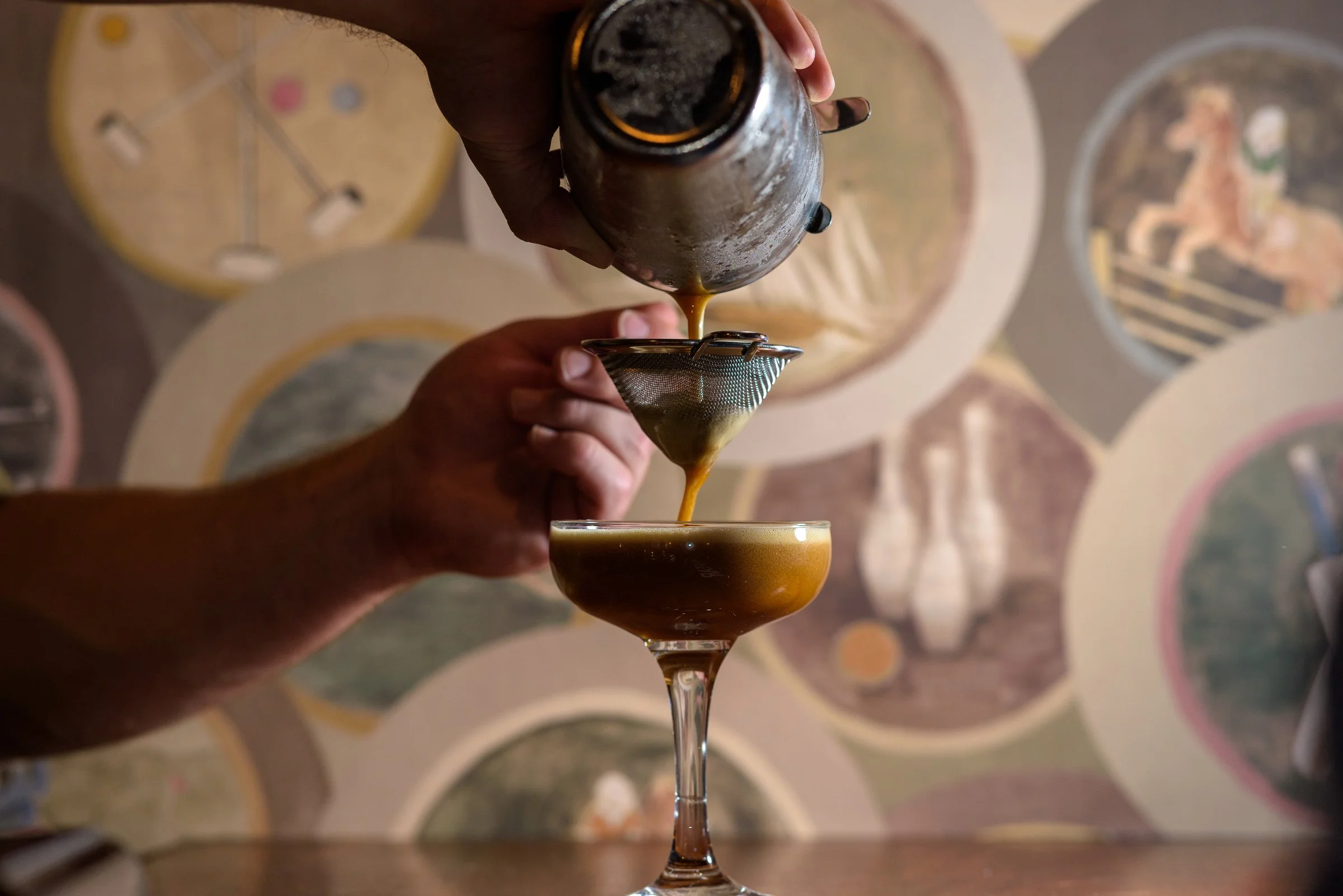 Seasonal dishes complemented by crafted cocktails, espresso martini being poured to perfection