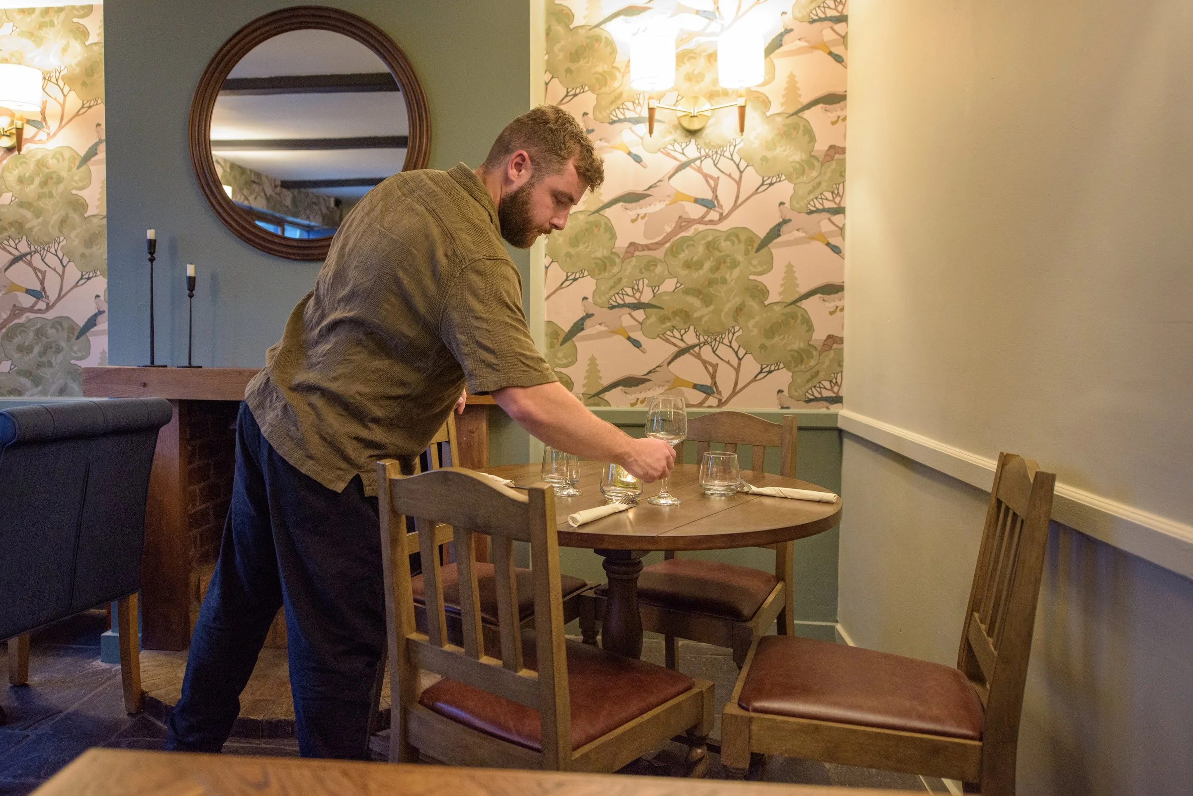 Pub staff preparing a cosy table setting for guests to enjoy seasonal dishes