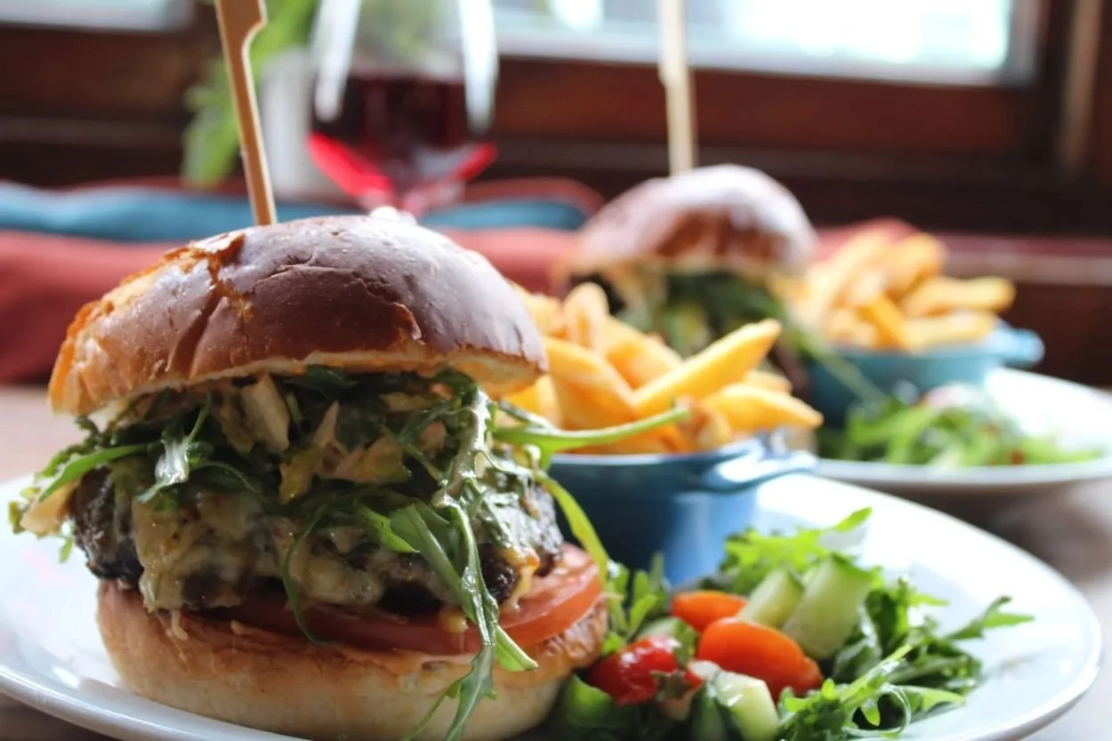 Delicious burger with fries and fresh salad served in a casual dining setting