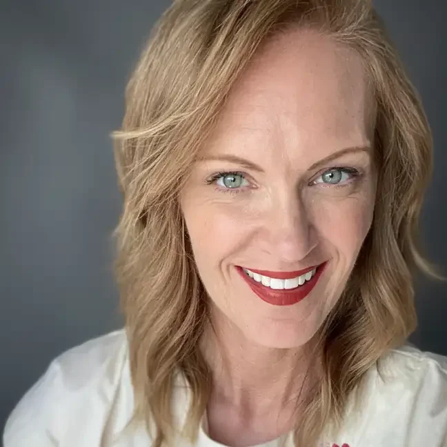 A professional headshot of a girl with red hair smiling