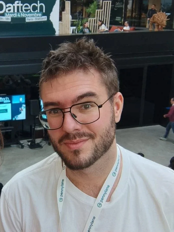 Homme avec des lunettes souriant à l'intérieur de station F