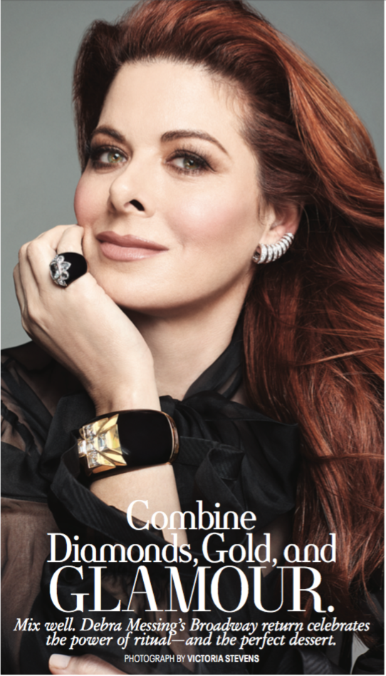 A woman with long red hair wearing jewelry, including rings and earrings, looks directly at the camera with a slight smile against a gray background. Text on the image promotes combining diamonds, gold, and glamour, celebrating Debra Messing's Broadw
