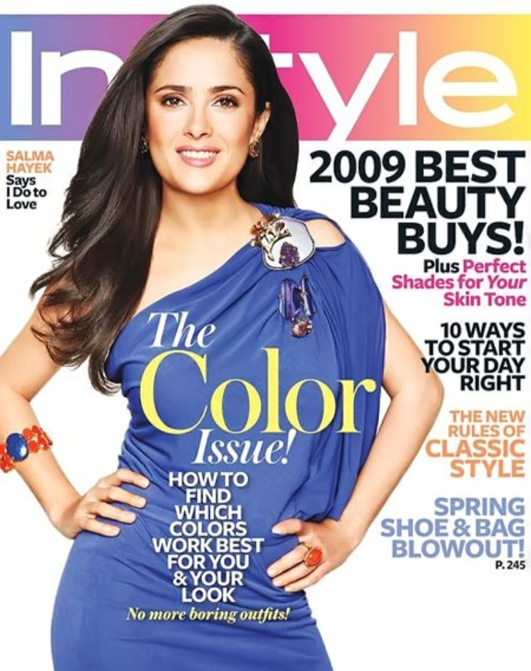 Cover of InStyle magazine featuring a woman in a blue dress with long dark hair, smiling and posing with one hand on her hip. The magazine highlights include topics about color fashion, beauty tips, and style trends for spring.
