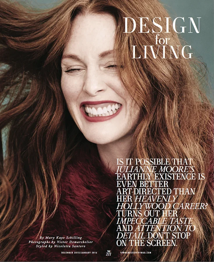 A woman with long red hair smiling with eyes closed, wearing a burgundy fluffy coat, on the cover of a magazine titled 'Design for Living.'