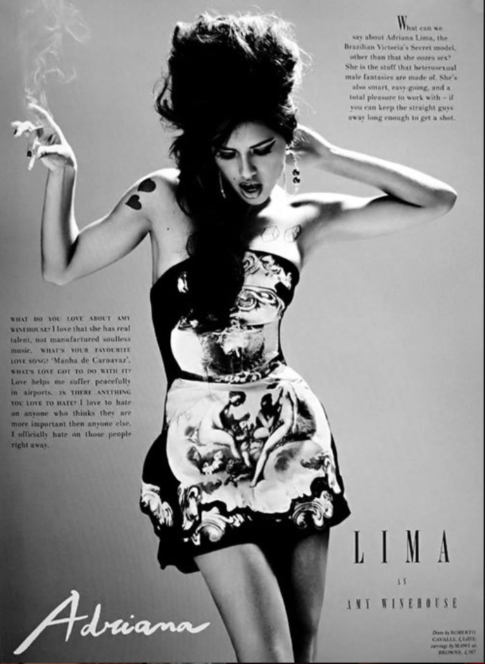 Photograph of a woman with dark, styled hair wearing a strapless dress with artistic faces and scenes. She has tattoos on her arm and is posing with one hand on her head and the other raised. The image is in black and white with text surrounding her,