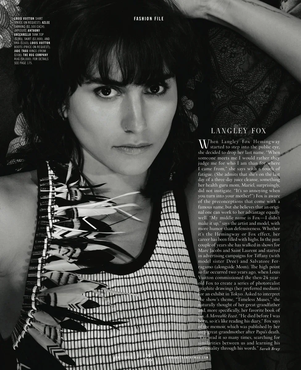 Black and white photo of a woman with dark hair, wearing a patterned top with feather detail, and a nose ring.