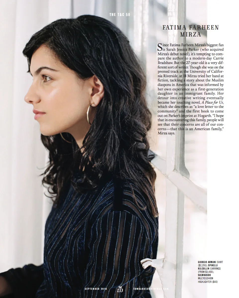 Side profile of a woman with dark, wavy hair looking out a window, wearing hoop earrings and a striped shirt.