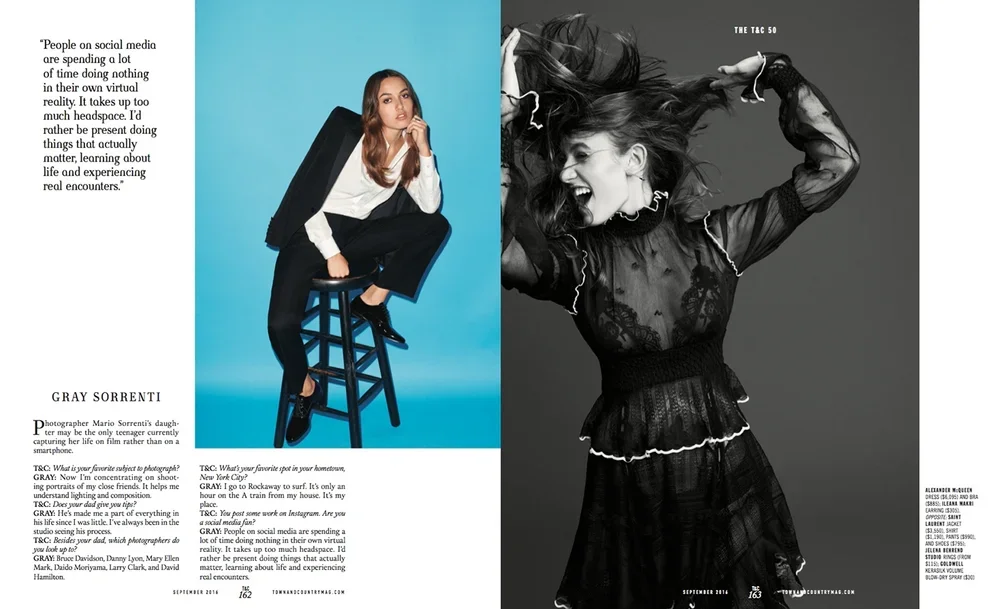 A two-page magazine spread with a photo of a woman on the right in black lace dress with her hair flying, expressive pose, and a woman on the left sitting on a chair against a light blue background with text.