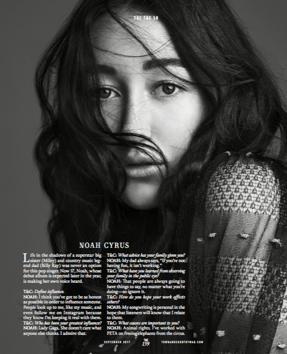 Black and white photo of a woman with long hair partially covering her face, looking directly at the camera.