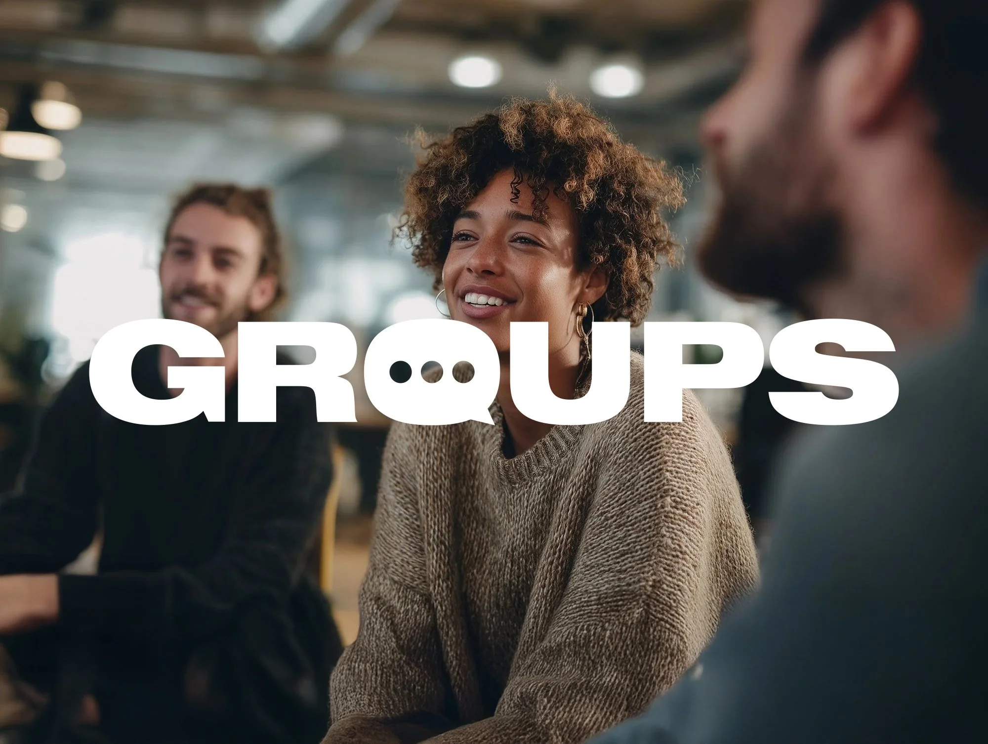 Three people sitting at a table engaging in conversation in a social setting, with the word 'GROUPS' overlayed on the image.