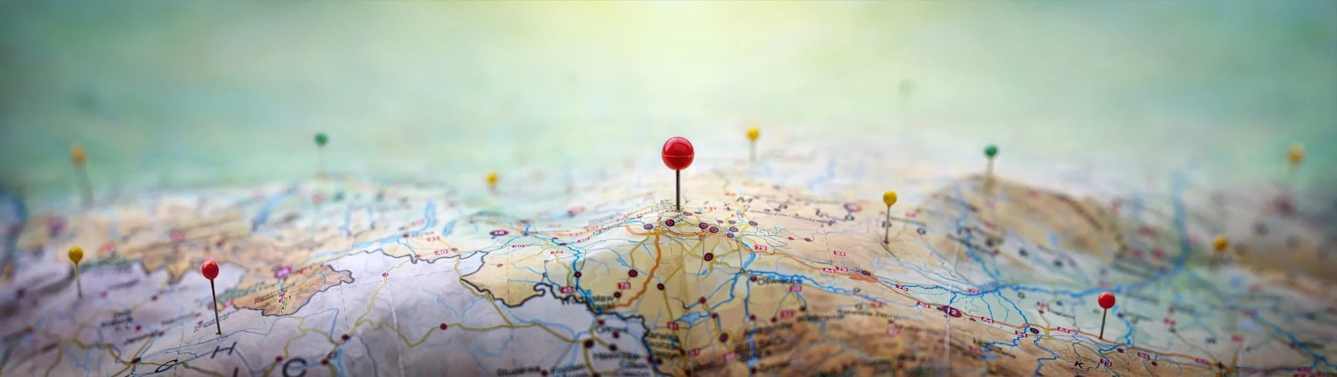 Close-up of a map with multiple colored pins marking locations