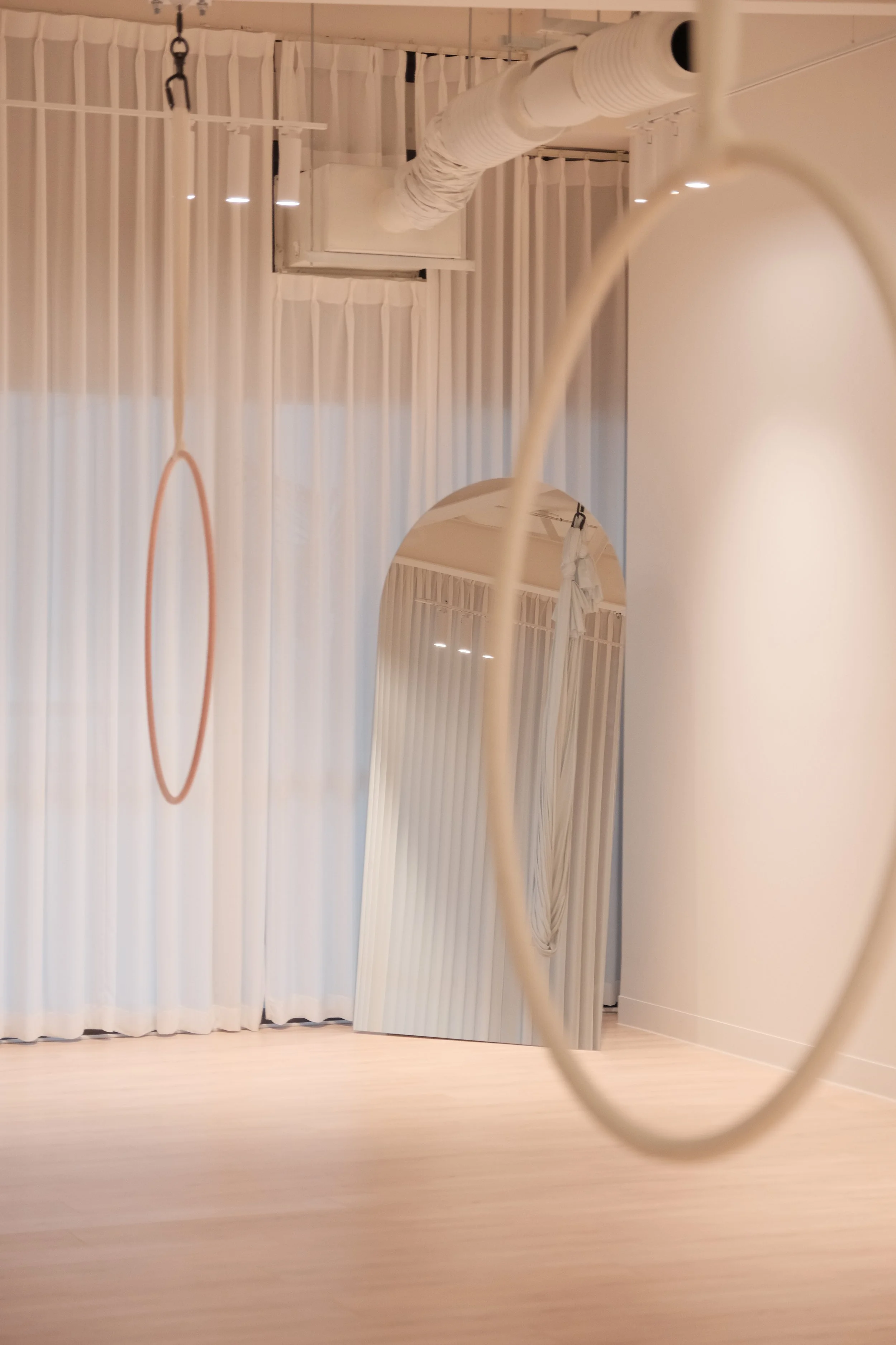 Aerial hoop and hammock training space in Melbourne CBD with soft fabrics and a spacious, minimal interior.